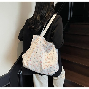 Detail of floral canvas tote bag with pink and blue patterns on white fabric