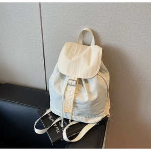 Détail du sac à dos en nylon imperméable blanc cassé avec cordon et boucle argentée
