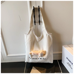 Detail of white canvas tote with 3D yellow plush doll and DIDI DOG print