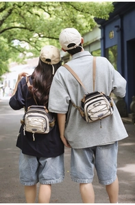 Outdoor street style view of beige and charcoal versatile crossbody bag on models