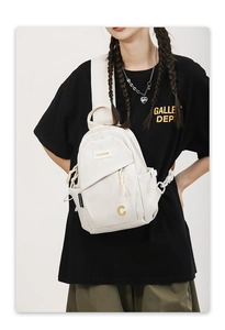 Detail of off-white nylon mini backpack showing front zipper and brand logo patch