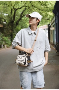 Detail of beige and black crossbody bag with adjustable strap and functional buckle closure