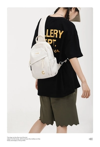 Close-up of white nylon crossbody chest bag showing multi-pocket storage and durable zippers