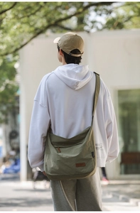 Outdoor back view of army green waterproof oxford cloth crossbody bag with wide strap