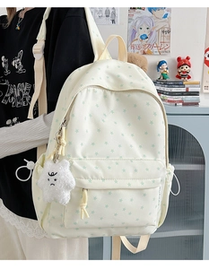 Macro detail of white backpack with green star patterns and cute plush star charm