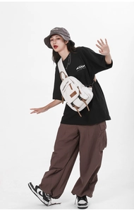 White tactical chest bag worn by a model showcasing nylon material and buckle details