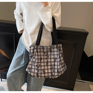 Detail of floral tote bag with black bear pattern shown on model's shoulder style