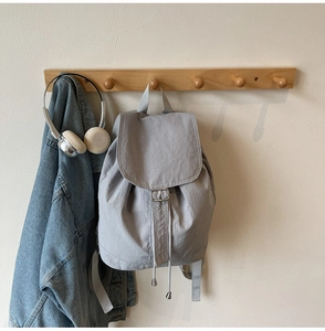 Sac à dos minimaliste en nylon gris clair suspendu avec veste en jean et casque