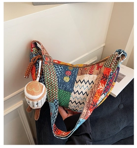Dettaglio borsa shopper patchwork con motivi vivaci e ciondolo a forma di tazza