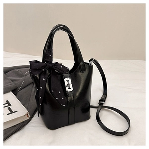 Dettaglio borsa a secchiello nera in pelle con foulard a pois e chiusura a girello in argento