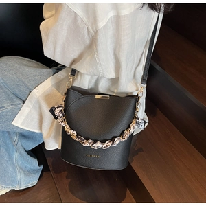 Détail du sac seau noir avec foulard en soie léopard sur la poignée en chaîne