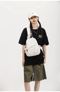 Detailed view of off-white multi-pocket crossbody chest bag with durable canvas texture
