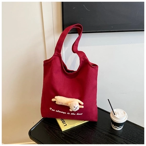 Detail of burgundy canvas tote bag featuring a cute 3D plush bear and stylish lettering