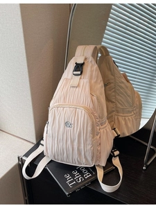 Minimalist beige crossbody bag with pleated texture and silver logo for travel