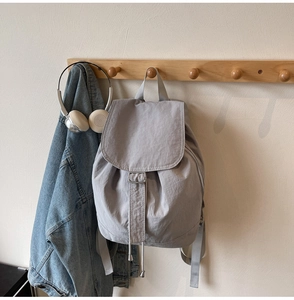 Sac à dos en nylon gris clair avec cordon de serrage et boucles argentées au mur