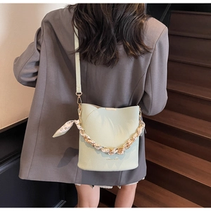 Détail du sac seau vert menthe avec anse en chaîne de soie et texture en cuir de litchi