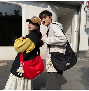Outdoor lifestyle shot of red and black waterproof nylon crossbody dumpling bags