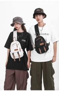 Detail of cargo crossbody bags in black and white with tactical buckles and brown handles