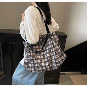 Detail of large canvas tote bag with black and white checkered floral pattern on shoulder