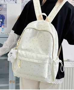 Detailed back view of cream canvas backpack with green star print and cloud charm