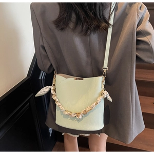 Détail du sac seau vert menthe avec texture litchi et chaîne métallique en foulard floral