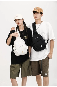 Detail showing high-capacity nylon chest bags with multiple zippers in black and cream