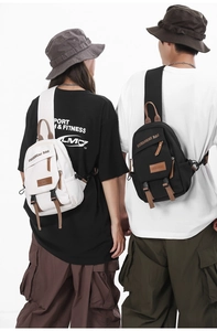 Close-up of adjustable shoulder straps and brown leather accents on canvas chest bags