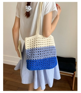 Full body view of a woman wearing a tri-color hollow knit crochet shoulder tote bag
