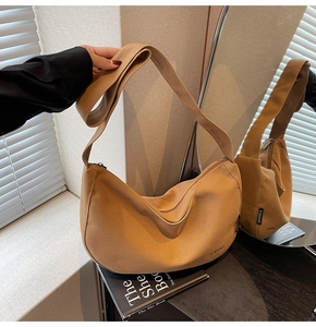 Detailaufnahme der braunen Canvas-Halbmondtasche mit verstellbarem Riemen und Spiegelung