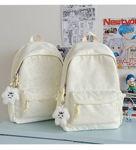 Detail of beige canvas backpacks with star prints and white plush star charms