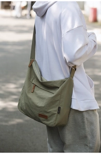 Outdoor shot of army green waterproof crossbody bag showing side profile and large capacity