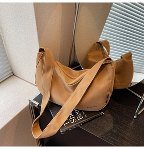 Detailaufnahme der braunen Hobo-Tasche aus Canvas mit Stoffstruktur und dezentem Logo