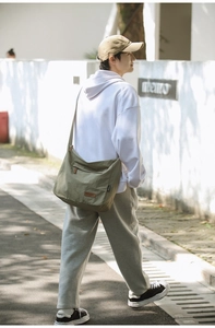 Outdoor shot of olive green oxford crossbody bag showing fit and adjustable strap