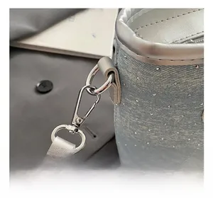 Gros plan sur la texture en denim bleu clair avec strass et crochet en métal argenté brillant