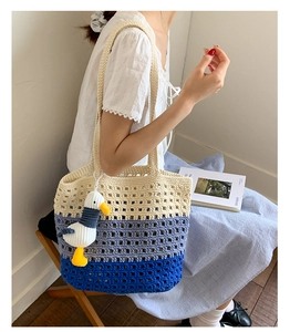 Close-up of three-color gradient crochet tote bag with seagull plush charm and mesh texture