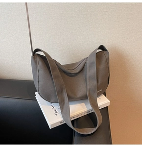 Detail einer großen Canvas Hobo-Tasche in Dunkelkhaki mit MANQI Logo und Gurt