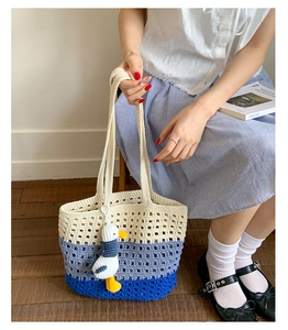 Close-up of the beige and blue gradient hollow crochet tote bag with a cute plush charm