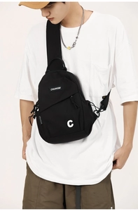 Detail of black nylon crossbody bag featuring large C print and adjustable wide strap