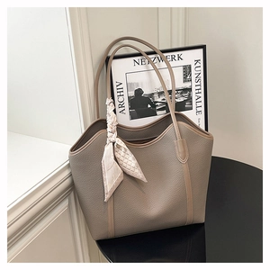Detail of large beige leather tote bag with lychee texture and floral silk scarf