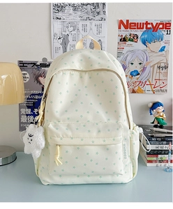 Detail of star-pattern canvas backpack featuring side pockets and plush cloud pendant