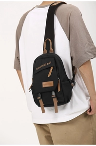 Detail of crossbody chest bag showing nylon material and leather zipper puller on model