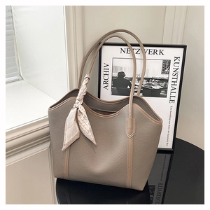 Close-up of taupe tote bag with lychee grain texture and floral silk scarf detail