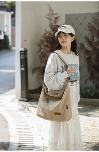 Outdoor shot of a durable khaki canvas crossbody bag with wide strap and moon shape design