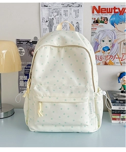 Close-up of beige canvas backpack featuring green star patterns and side drawstring pocket