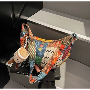 Dettaglio della borsa a mezzaluna patchwork boho con ciondolo a tazza e fibbie in metallo