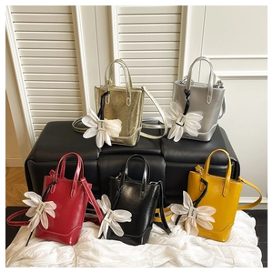 Vertikale Mini-Handtaschen in fünf Farben mit auffälligen weißen Blumenanhängern
