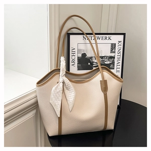 Detail of beige tote bag with brown straps, lychee texture leather and a floral silk scarf