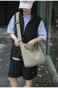 Detail of a large nylon drawstring crossbody bag with adjustable wide shoulder strap