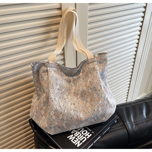 Detail of floral lace texture and beige woven strap on a large canvas tote bag