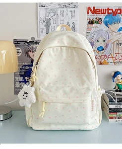 Detail of star pattern canvas backpack with plush star charm on a study desk